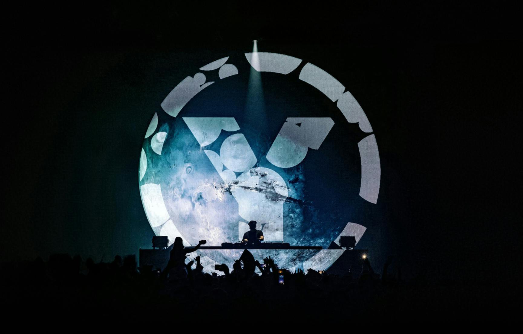 a crowd of people at a dj's party